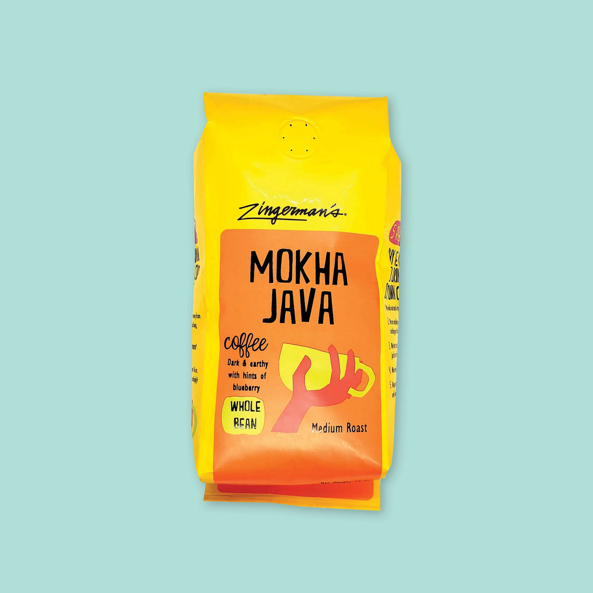 On a cool aqua background is a bright yellow orange bag of coffe. The coffee is Zingerman's brand Roadhouse Joe Blend. 'Smooth as silk and served daily at Zingerman's Roadhouse' Ground coffee. 12 oz (350 g). 