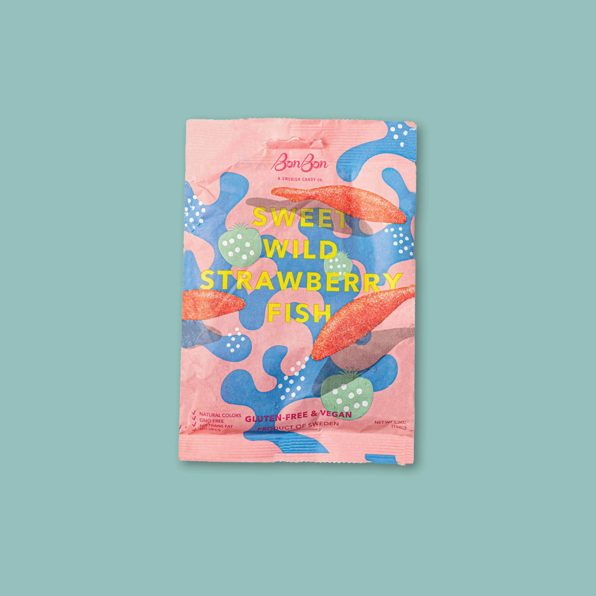 On a turquoise background sits a pouch of Sweet Wild Strawberry Fish candies from BonBon.